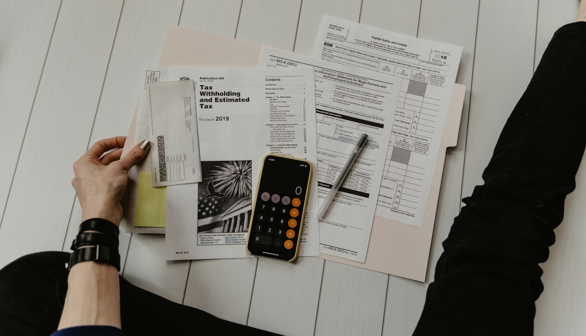Financial documents and a calculator arranged on a working desk
